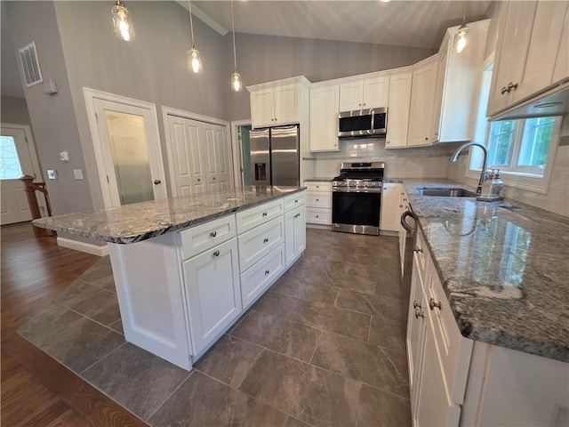 475 Danielson Pike, Scituate, RI 02857 - kitchen with appliances with stainless steel finishes, a kitchen island, white cabinetry, backsplash, and high vaulted ceiling
