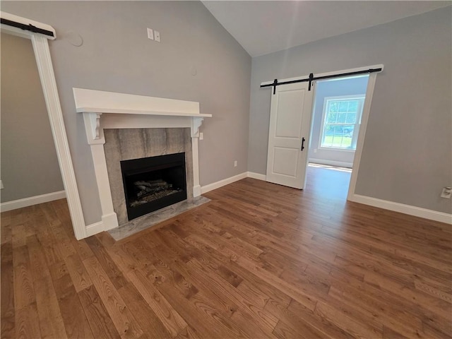 475 Danielson Pike, Scituate, RI 02857 - unfurnished living room featuring a barn door, lofted ceiling, wood finished floors, and a tiled fireplace