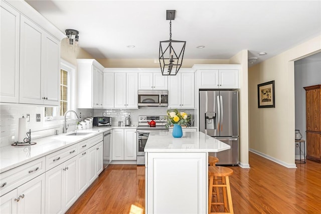 3 Piezzo Dr, Westerly, RI 02891 - kitchen with appliances with stainless steel finishes, a kitchen bar, white cabinetry, decorative backsplash, and recessed lighting