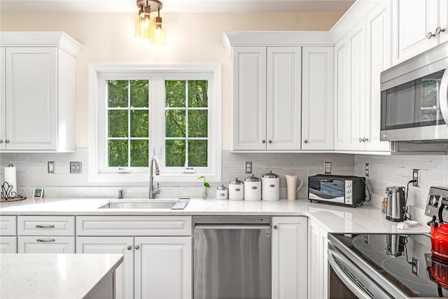 3 Piezzo Dr, Westerly, RI 02891 - kitchen with stainless steel appliances, white cabinets, tasteful backsplash, and light stone counters