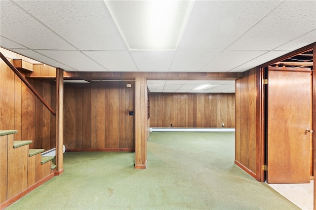 15 Rutland St, Warwick, RI 02888 - finished below grade area featuring carpet, a baseboard heating unit, a drop ceiling, wood walls, and stairs