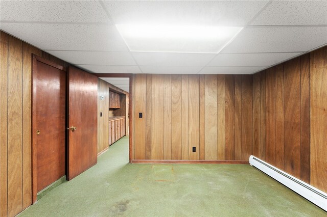 15 Rutland St, Warwick, RI 02888 - finished below grade area with a baseboard heating unit, carpet, a paneled ceiling, and wooden walls