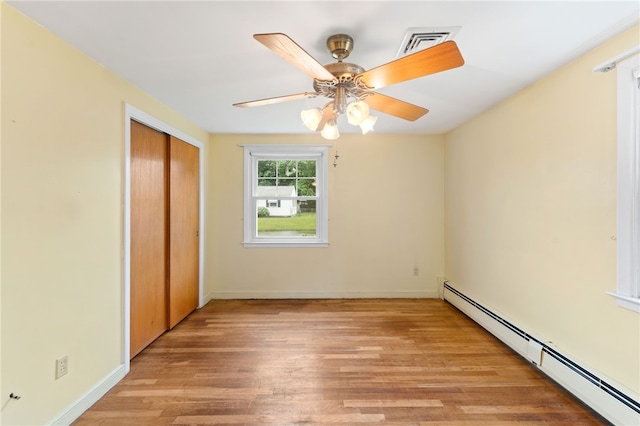 15 Rutland St, Warwick, RI 02888 - unfurnished bedroom with a baseboard radiator, light wood finished floors, a closet, and a ceiling fan