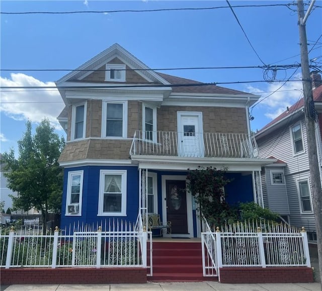 64 Elmdale Ave, Providence, RI 02909 - view of front facade featuring a porch, a fenced front yard, a balcony, and stone siding