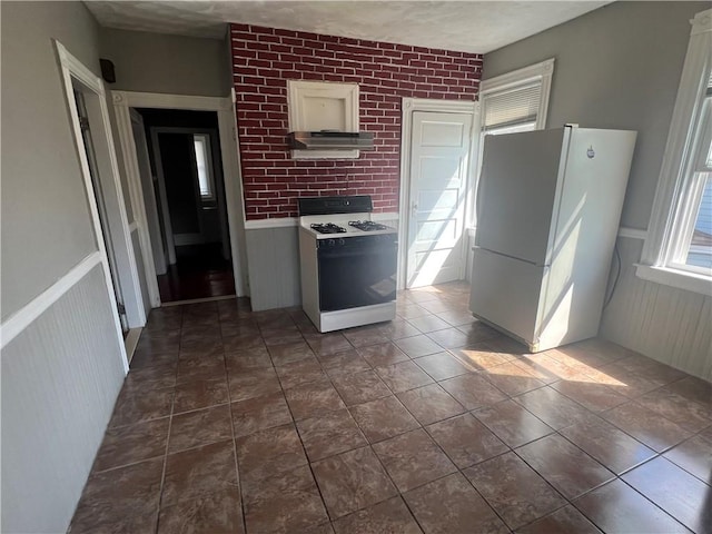 64 Elmdale Ave, Providence, RI 02909 - kitchen with range with gas cooktop, freestanding refrigerator, under cabinet range hood, wainscoting, and light countertops