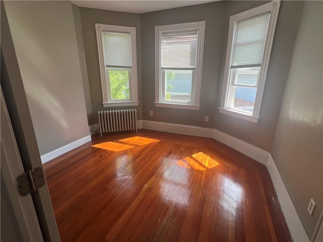 64 Elmdale Ave, Providence, RI 02909 - empty room with radiator, plenty of natural light, and hardwood / wood-style floors