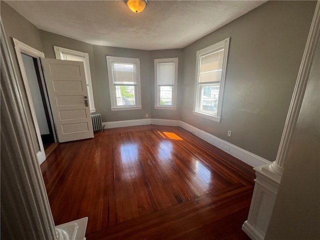 64 Elmdale Ave, Providence, RI 02909 - empty room featuring radiator, hardwood / wood-style floors, and decorative columns