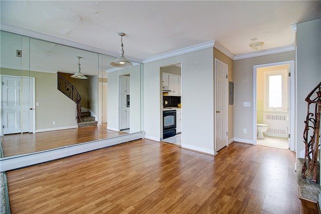 400 Narragansett Pkwy Unit Ei 2, Warwick, RI 02888 - unfurnished living room featuring radiator, stairway, crown molding, wood finished floors, and electric panel