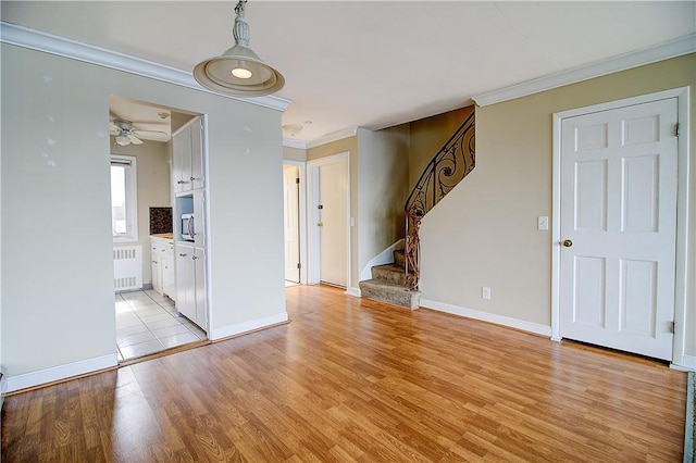 400 Narragansett Pkwy Unit Ei 2, Warwick, RI 02888 - unfurnished living room with ornamental molding, radiator heating unit, stairway, light wood-style floors, and ceiling fan