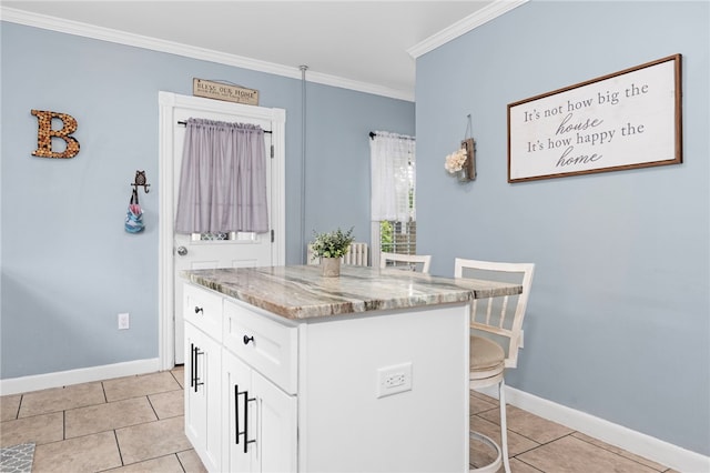 229 Roger Williams Ave, East Providence, RI 02916 - kitchen featuring light stone counters, a kitchen breakfast bar, ornamental molding, light tile patterned floors, and white cabinetry