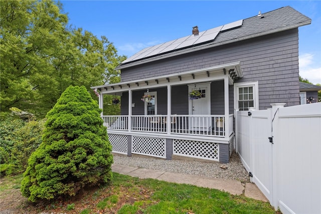 229 Roger Williams Ave, East Providence, RI 02916 - view of front facade featuring covered porch, solar panels, a gate, and a chimney