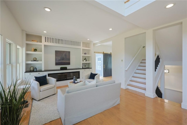 26 Old Stone Church Rd, Little Compton, RI 02837 - living area featuring a barn door, stairs, recessed lighting, light wood-style flooring, and a skylight