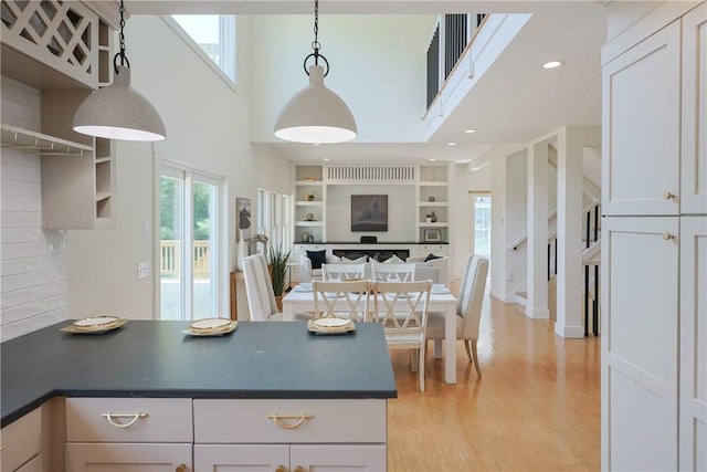 26 Old Stone Church Rd, Little Compton, RI 02837 - kitchen with dark countertops, a high ceiling, open floor plan, light wood finished floors, and open shelves