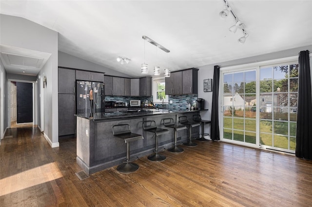 94 Waterman Ave, Warwick, RI 02889 - kitchen with freestanding refrigerator, a peninsula, dark countertops, dark wood-style floors, and tasteful backsplash