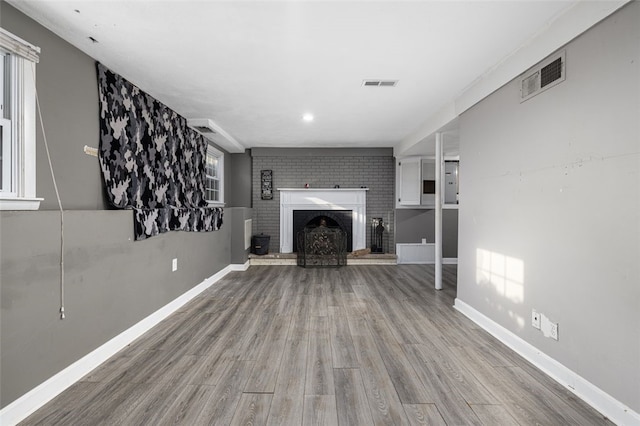 94 Waterman Ave, Warwick, RI 02889 - unfurnished living room featuring wood finished floors and a brick fireplace