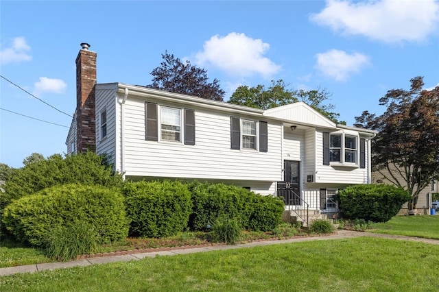 94 Waterman Ave, Warwick, RI 02889 - split foyer home with a chimney and a front lawn