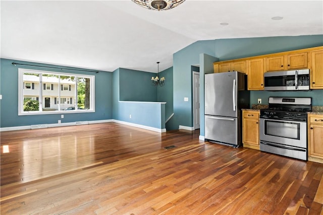 11 Tupelo Trl, Narragansett, RI 02882 - kitchen with stainless steel appliances, a chandelier, vaulted ceiling, wood finished floors, and dark stone countertops