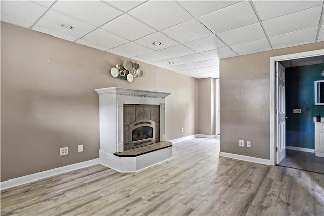 11 Tupelo Trl, Narragansett, RI 02882 - unfurnished living room featuring a drop ceiling, wood finished floors, a fireplace with raised hearth, and recessed lighting