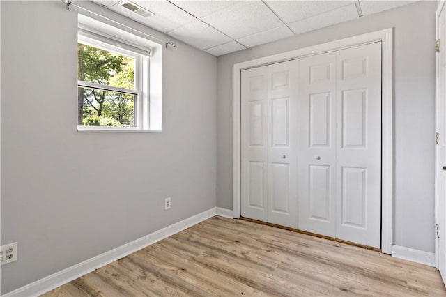 11 Tupelo Trl, Narragansett, RI 02882 - unfurnished bedroom with light wood-style flooring, a closet, and a paneled ceiling