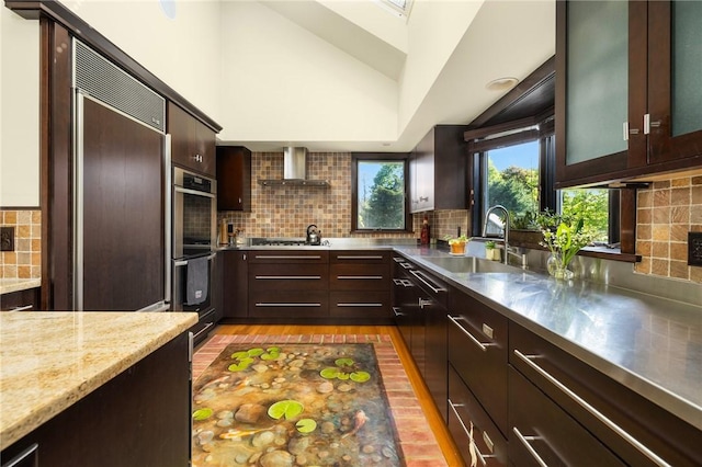 11 Mill Brook Ct, Charlestown, RI 02813 - kitchen with wall chimney exhaust hood, stainless steel countertops, stainless steel appliances, tasteful backsplash, and dark brown cabinetry