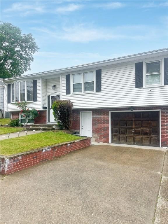 253 Nelson St, Providence, RI 02908 - bi-level home with an attached garage, brick siding, and concrete driveway