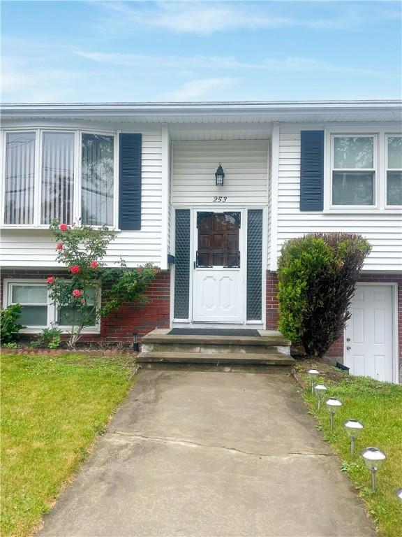 253 Nelson St, Providence, RI 02908 - view of exterior entry featuring brick siding and a yard