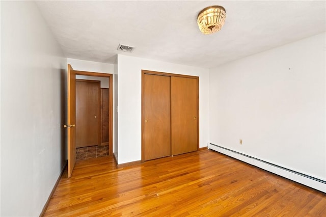 253 Nelson St, Providence, RI 02908 - unfurnished bedroom featuring a baseboard heating unit, light wood finished floors, and a closet