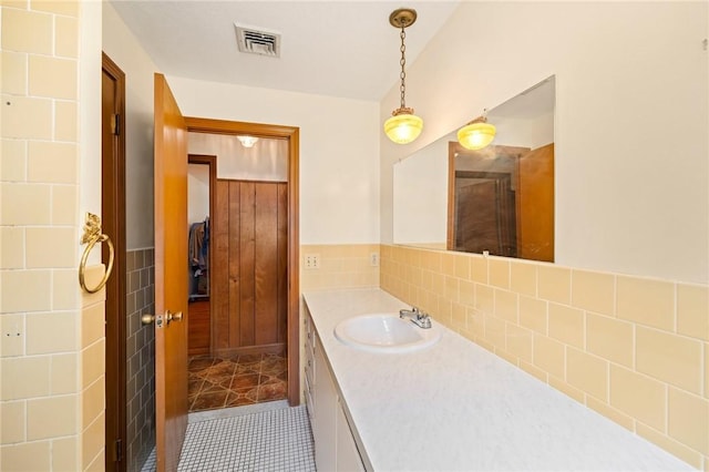 253 Nelson St, Providence, RI 02908 - bathroom with vanity, tile walls, tile patterned floors, and a wainscoted wall