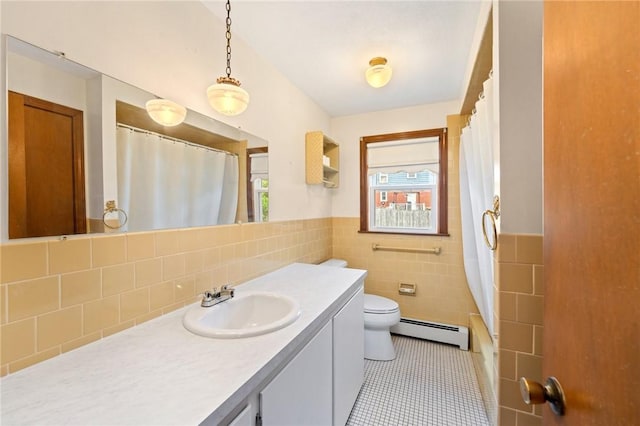 253 Nelson St, Providence, RI 02908 - bathroom with a baseboard radiator, vanity, tile walls, tile patterned floors, and a wainscoted wall