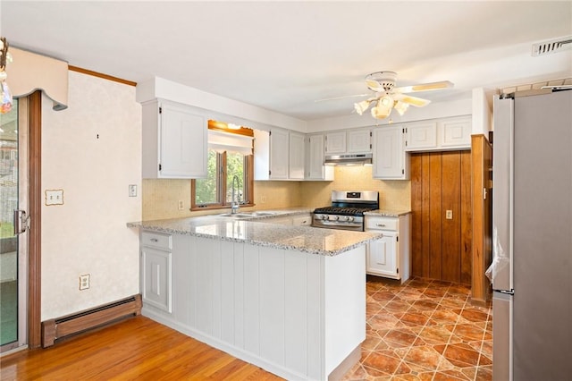 253 Nelson St, Providence, RI 02908 - kitchen featuring appliances with stainless steel finishes, a baseboard radiator, a peninsula, under cabinet range hood, and a ceiling fan