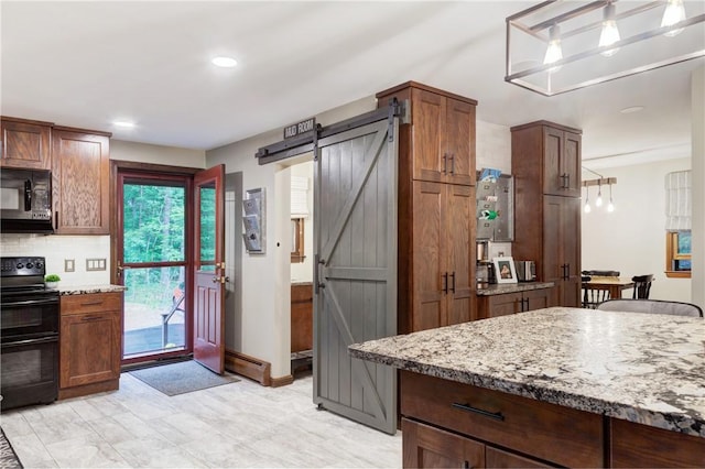 536 Douglas Hook Rd, Glocester, RI 02814 - kitchen with black appliances, a barn door, decorative backsplash, light stone counters, and recessed lighting