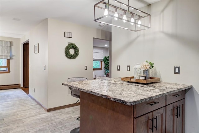 536 Douglas Hook Rd, Glocester, RI 02814 - kitchen featuring a breakfast bar area, a baseboard radiator, light wood-type flooring, a chandelier, and decorative light fixtures