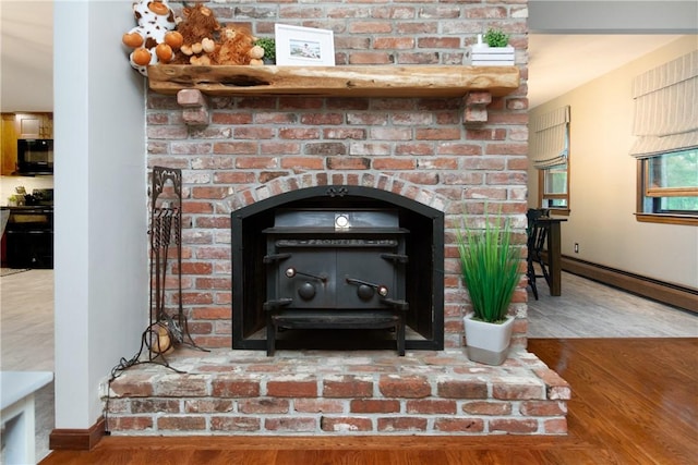 536 Douglas Hook Rd, Glocester, RI 02814 - detailed view of black appliances, a fireplace, wood finished floors, and a baseboard radiator