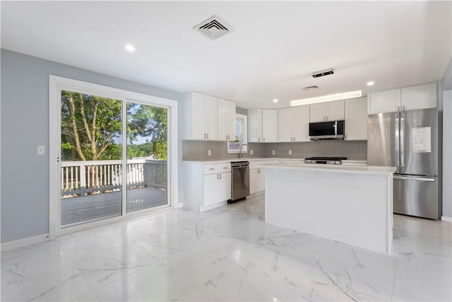 57 Wilson Ave, Johnston, RI 02919 - kitchen with stainless steel appliances, decorative backsplash, light marble finish floors, white cabinets, and recessed lighting