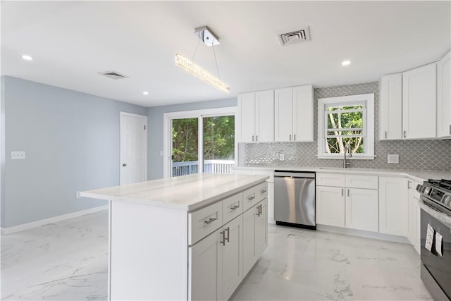 57 Wilson Ave, Johnston, RI 02919 - kitchen featuring stainless steel appliances, light marble finish floors, tasteful backsplash, white cabinets, and recessed lighting