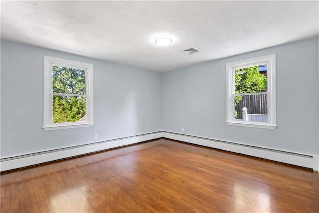 57 Wilson Ave, Johnston, RI 02919 - empty room featuring dark wood-type flooring and a baseboard heating unit