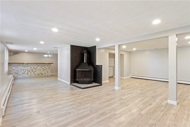 57 Wilson Ave, Johnston, RI 02919 - finished basement featuring a wood stove, baseboard heating, recessed lighting, light wood-style floors, and bar area