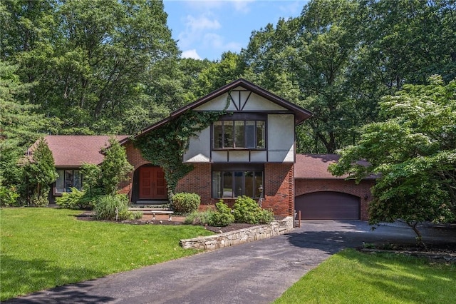 9 Beacon Hill Dr, Warwick, RI 02886 - tudor home with driveway, a front yard, brick siding, an attached garage, and stucco siding