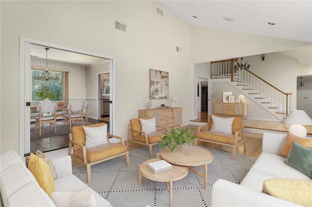 9 Beacon Hill Dr, Warwick, RI 02886 - living room with stairway, high vaulted ceiling, a chandelier, and wood finished floors