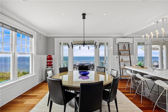 1210 Graces Cove Rd, Block Island, RI 02807 - dining area featuring a chandelier, a wall unit AC, healthy amount of natural light, a water view, and crown molding