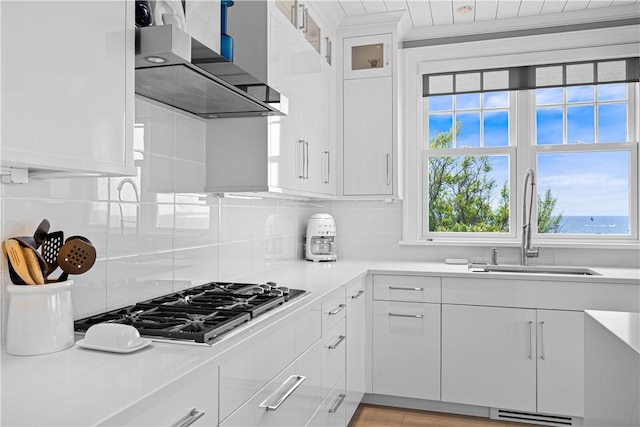 1210 Graces Cove Rd, Block Island, RI 02807 - kitchen with wall chimney range hood, stainless steel gas cooktop, light countertops, and healthy amount of natural light