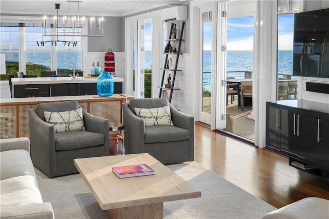 1210 Graces Cove Rd, Block Island, RI 02807 - living area with a wall unit AC, wood finished floors, crown molding, and a chandelier