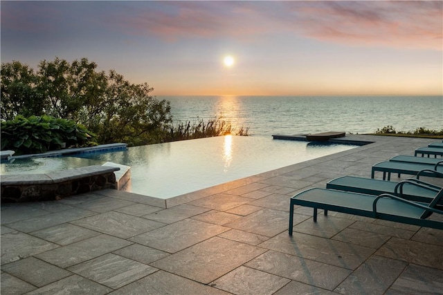1210 Graces Cove Rd, Block Island, RI 02807 - pool at dusk with a water view, an infinity pool, a hot tub, and a patio