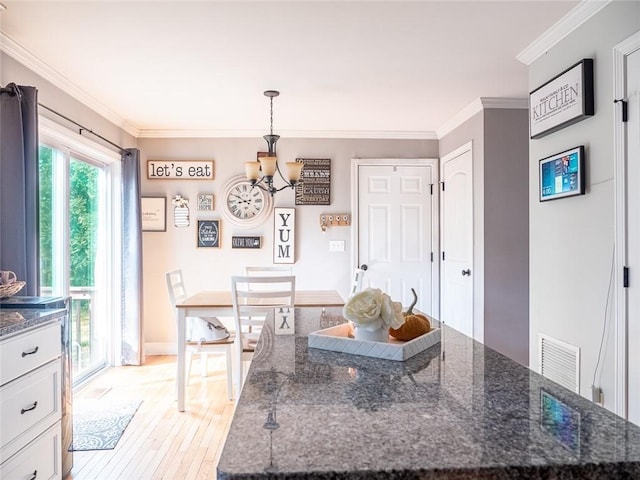19 Revere Ave, West Warwick, RI 02893 - kitchen with a chandelier, light wood-type flooring, crown molding, white cabinets, and dark stone countertops