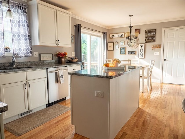 19 Revere Ave, West Warwick, RI 02893 - kitchen with stainless steel dishwasher, light wood-type flooring, ornamental molding, white cabinetry, and decorative light fixtures