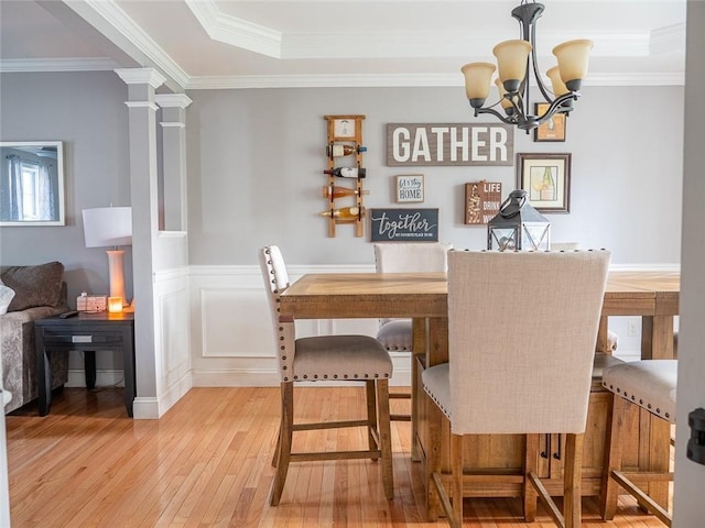 19 Revere Ave, West Warwick, RI 02893 - dining room featuring light wood finished floors, a chandelier, ornamental molding, and decorative columns