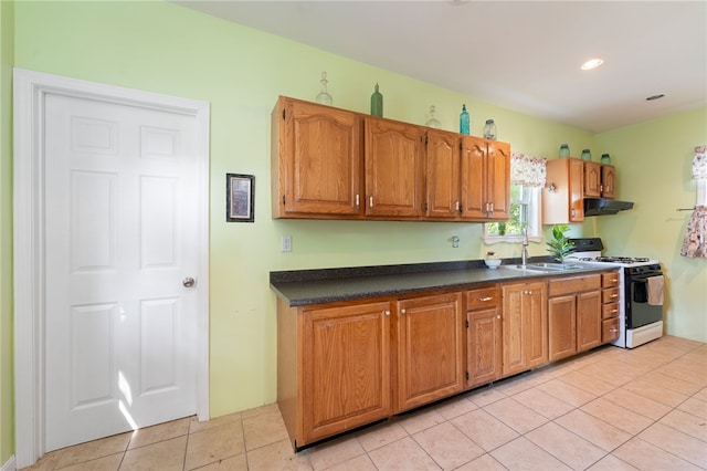 49 Palmer Ave, Warwick, RI 02889 - kitchen featuring gas range gas stove, under cabinet range hood, dark countertops, light tile patterned floors, and brown cabinets