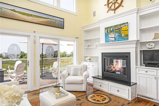 37 Teal Rd, South Kingstown, RI 02879 - living area with hardwood / wood-style flooring, built in shelves, a multi sided fireplace, and a high ceiling