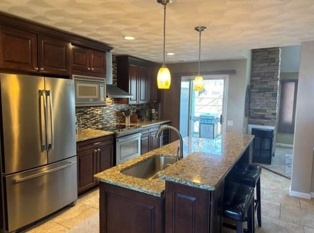 88 Nipmuc Trl Unit C, North Providence, RI 02904 - kitchen with appliances with stainless steel finishes, tasteful backsplash, light stone countertops, an island with sink, and hanging light fixtures