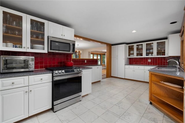 788 Namquid Dr, Warwick, RI 02888 - kitchen with appliances with stainless steel finishes, backsplash, white cabinets, glass insert cabinets, and open shelves